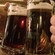 Jarras llenas de cerveza negra se chocan en un brindis